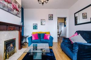 a living room with two blue couches and a fireplace at Cosy 2 Bedroom house-Short drive from Blackpool Pleasure Beach in Blackpool