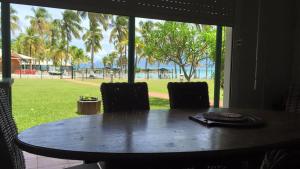 a table and chairs with a view of the ocean at ocean view, on the beach. in Le Gosier