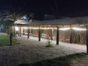 a building with pink chairs and lights at night at Descanso los palmitos in Cuatrociénegas de Carranza