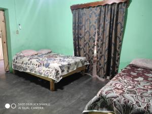 1 dormitorio con 2 camas y cortina en Descanso los palmitos en Cuatrociénegas de Carranza