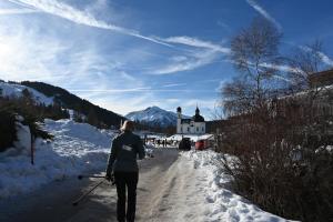 uma pessoa andando por uma estrada coberta de neve em Hotel Hocheder em Seefeld no Tirol