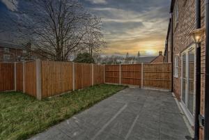 uma cerca de madeira ao lado de um quintal com um passeio em Central and Stylish, Garden and Parking em Coventry