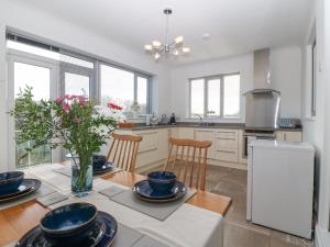 a kitchen with a table with a vase of flowers at Riverview Apartment in Cemaes Bay
