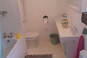 een witte badkamer met een toilet en een wastafel bij Cosy cottage+ secluded garden in Kent