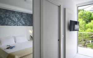 1 dormitorio con 1 cama y puerta corredera de cristal en Grand Hotel Playa, en Lignano Sabbiadoro