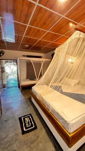 a bedroom with a bed with a mosquito net at Hakuna Matata Arugambay in Arugam Bay