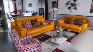 een woonkamer met twee gele banken en een tafel bij Maison de 3 chambres avec jardin clos et wifi a Champcueil in Champcueil