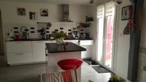 une cuisine avec un comptoir et un tabouret rouge dans l'établissement Maison de 3 chambres avec jardin clos et wifi a Champcueil, à Champcueil