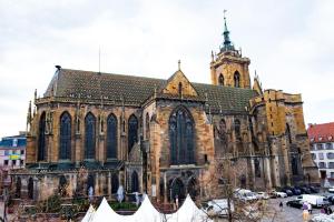 an old church with a tower and a large building at B'm Hans - Centre Historique - Vue Cathédrale - 2P in Colmar