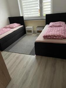2 Betten in einem Zimmer mit Holzböden in der Unterkunft FeWo und Monteurzimmer Wesel in Wesel
