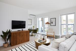 a living room with a couch and a tv at The Wembley Park Retreat - Modern 2BDR Flat with Balcony in London