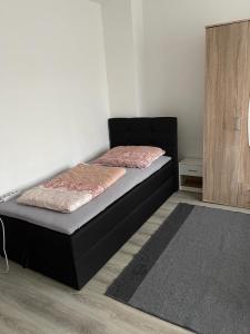 Schlafzimmer mit einem Bett und einem Holzschrank in der Unterkunft FeWo und Monteurzimmer Wesel in Wesel