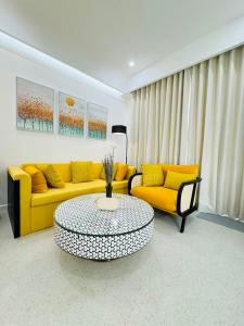 un soggiorno con divano giallo e tavolo di Oscar Seaview Apartment a Phu Quoc