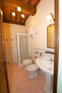 a bathroom with a toilet and a sink at Il Giardino in Asciano +23 photos