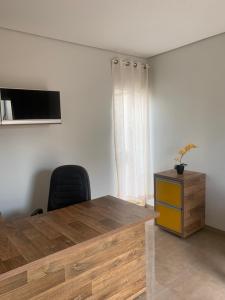 Habitación con mesa, silla y escritorio. en Linda Casa Próximo Aeroporto en Campo Grande