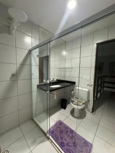 a bathroom with a glass shower and a toilet at Casa lagoa do pau- coruripe/AL - 300 metros da praia in Coruripe