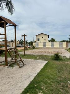 un parque infantil con una mesa de madera y un edificio en Casa lagoa do pau- coruripe/AL - 300 metros da praia, en Coruripe