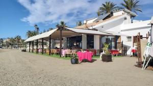 un restaurante en la playa con mesas y sillas en Del Parque Flats Picasso Townhouse, en Marbella