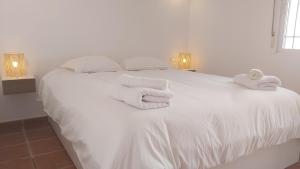 een slaapkamer met een wit bed met handdoeken erop bij Del Parque Flats Picasso Townhouse in Marbella +46 foto's