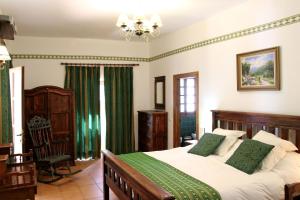 a bedroom with a large bed with green curtains at Ronda Nomads in Benaoján +12 photos