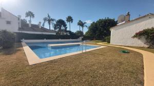 een zwembad in een tuin naast een huis bij Del Parque Flats Picasso Townhouse in Marbella
