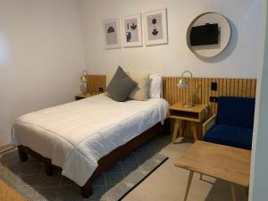 1 dormitorio con 1 cama y 1 silla azul en CHOLULA SUITES, en Cholula