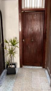 a wooden door with a potted plant in front of it at Casa Rosina agli Scavi Parcheggio Privato Incluso in Ercolano