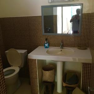 a bathroom with a sink and a toilet and a mirror at SAFARI Lodge Location Bungalow in Cap Skirring