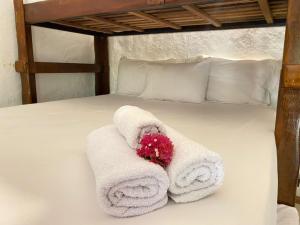 a bed with towels and a flower on it at Pousada Bate Vento in Itarema