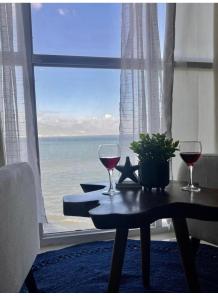 een tafel met twee wijnglazen en uitzicht op de oceaan bij Sun Flower in Portmore