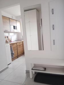 uma cozinha com armários brancos e um frigorífico em Mieszkanie Turkus w Gnieźnie em Gniezno