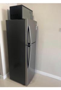 een koelkast met een magnetron erop bij Sun Flower in Portmore