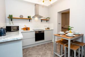 a kitchen with white appliances and a wooden table at Stay Coastal in Whitley Bay