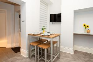 a small kitchen with a small table with plates on it at Stay Coastal in Whitley Bay