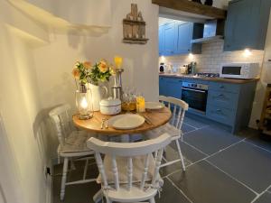a small kitchen with a wooden table and chairs at Cosy Fisherman’s Cottage: 150m to Brixham Harbour in Brixham