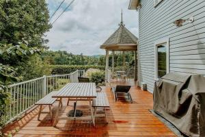 a wooden deck with a picnic table and a gazebo at Chalet - Le Blue Hill in Saint Adolphe D'Howard