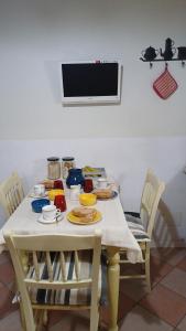 einen weißen Tisch mit Stühlen und einen TV an der Wand in der Unterkunft La Dolce Venezia Guesthouse in Venedig