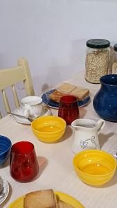 a table with different colored plates and bowls on it at La Dolce Venezia Guesthouse in Venice