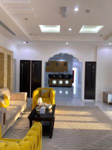 a living room with a yellow couch and a table at ANTIKA HOTEL / انتيكا للشقق الفندقيه in Firq