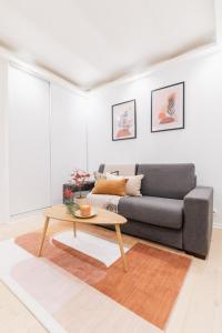 uma sala de estar com um sofá e uma mesa de centro em Imhost 8 - Lovely studio at St Michel-Notre Dame em Paris