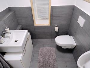 a bathroom with a white toilet and a sink at Ferienwohnung am Egelsee 