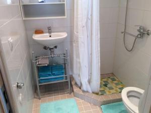 uma casa de banho com um lavatório, um chuveiro e um WC. em Cozy studio apartment em Talin