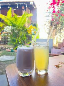 dos bebidas están sentadas en una mesa de madera en Mộc House, en Kon Tum Kơ Pang