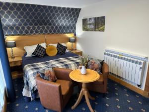 une chambre d'hôtel avec un lit, une table et des chaises dans l'établissement The Glen Hotel Newtonmore, à Newtonmore