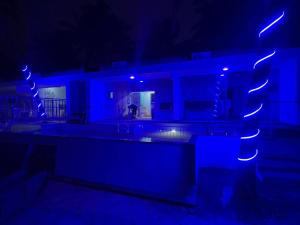 マンガロールにあるBlue Lagoon Homestayのブルーライト付きの暗い部屋、スイミングプール