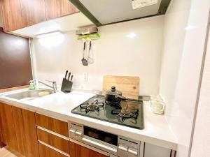 a small kitchen with a stove and a sink at East Ikebukuro 2 Double Beds Apartment / Sunshine City in Tokyo
