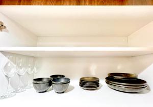a shelf with plates and wine glasses on it at East Ikebukuro 2 Double Beds Apartment / Sunshine City in Tokyo