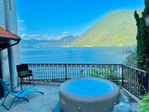 - un bain à remous sur une terrasse avec vue sur l'eau dans l'établissement Rustico con idromassaggio vista lago, à Brienno