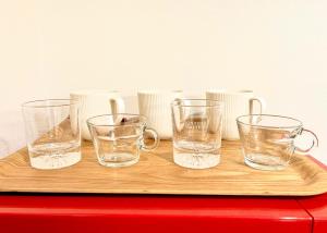 a group of glasses sitting on top of a wooden table at East Ikebukuro 2 Double Beds Apartment / Sunshine City in Tokyo