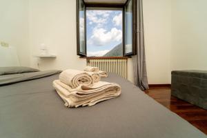 - une chambre dotée d'un lit avec couvertures et d'une fenêtre dans l'établissement Rustico con idromassaggio vista lago, à Brienno